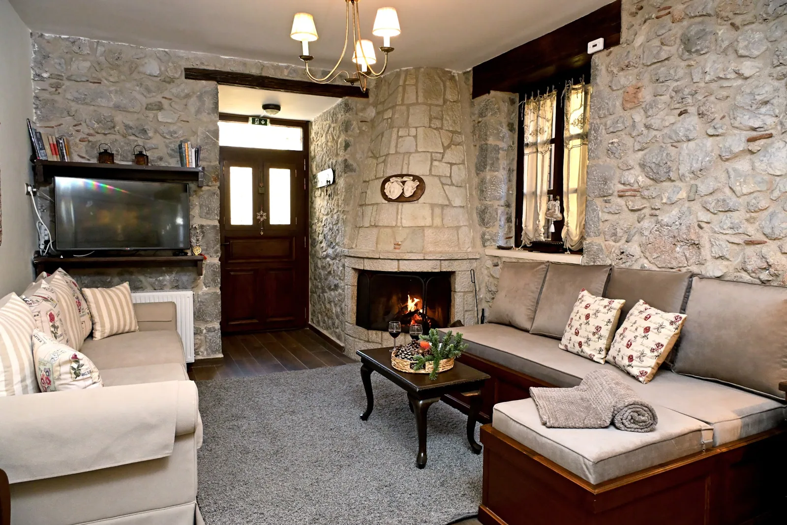 Warm Lithora living room with a lit stone fireplace